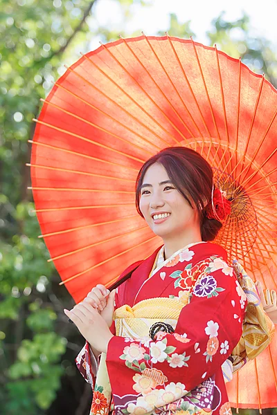成人式 赤い振袖と和傘を差す女性（野外撮影）